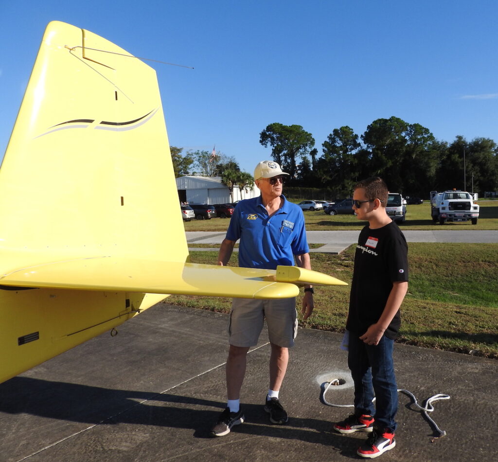 EAA Chapter 534 President Steve Tilford explains the use of the elevator on his plane to Jacob Hudson.