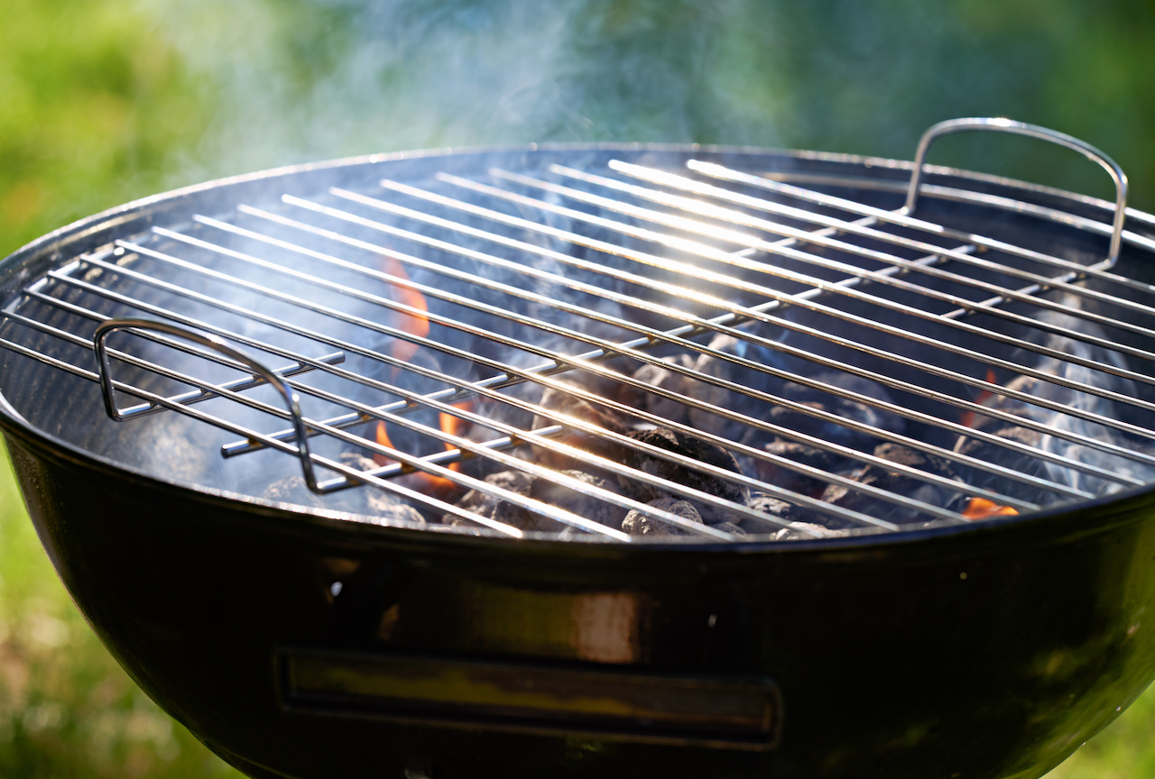 charcoal kettle grill warming up and ready to cook food in backyard
